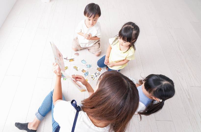 子どもたちに絵本を読み聞かせている